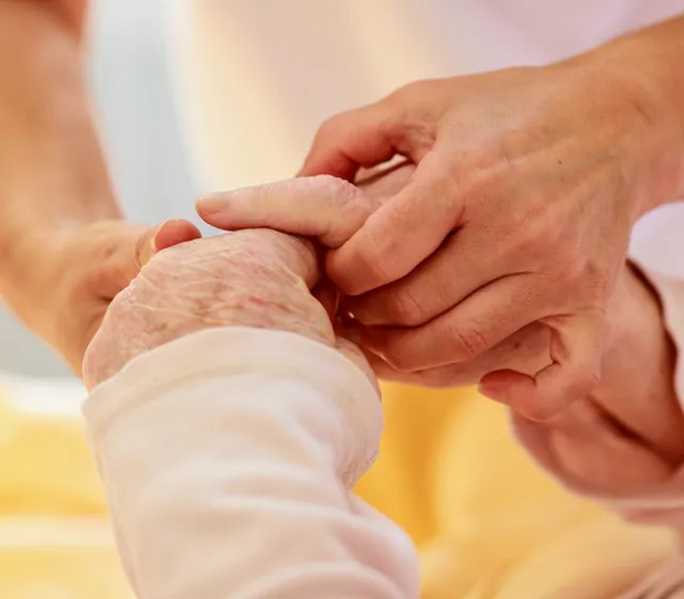 Zwei junge hände alten eine ältere Hand.